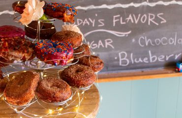 Donut tower on a table with todays flavors on a chalkboard
